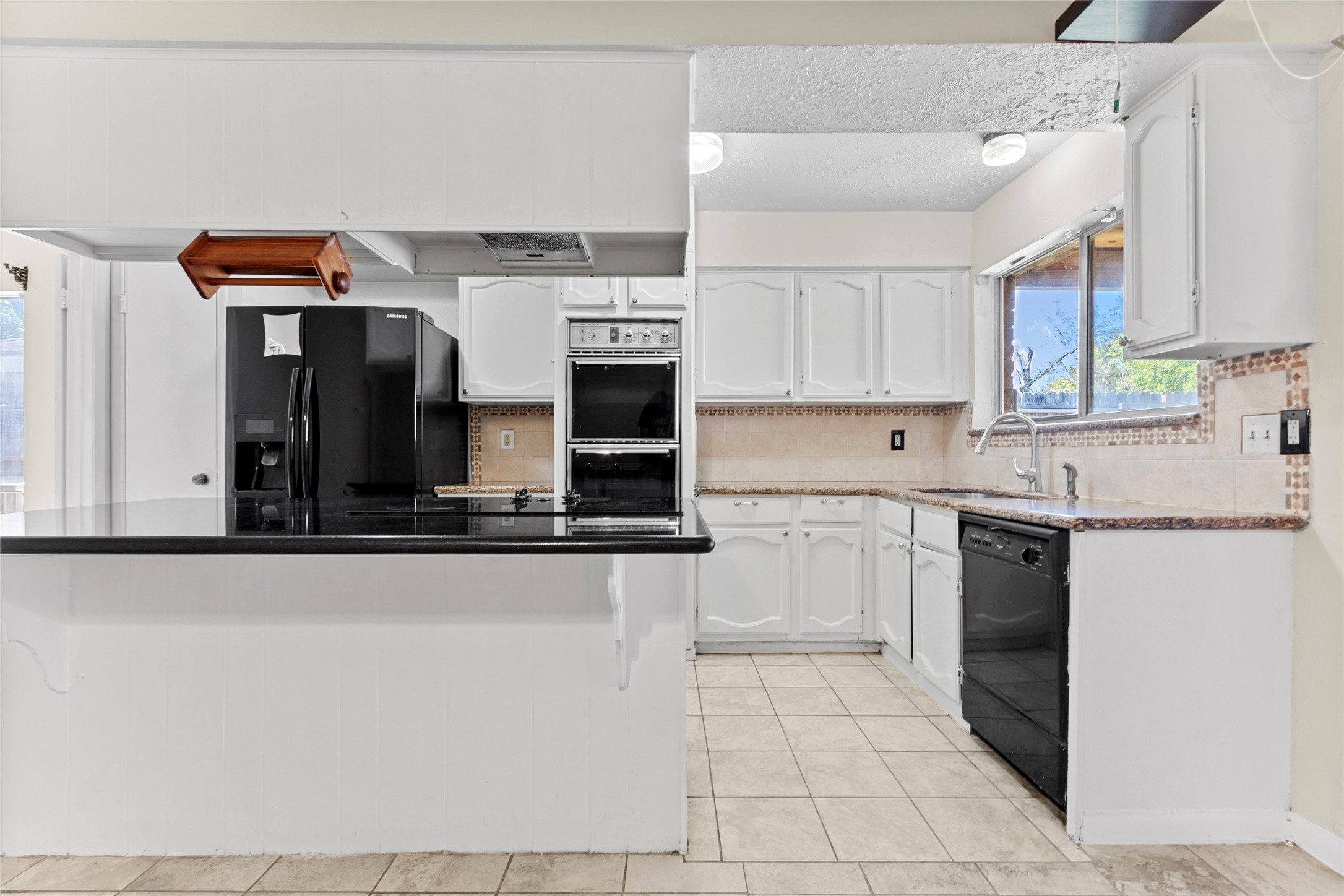 6630 Brownie Campbell Road Houston, TX 77086 - Photo 14 of 28 a kitchen with stainless steel appliances a sink and a refrigerator