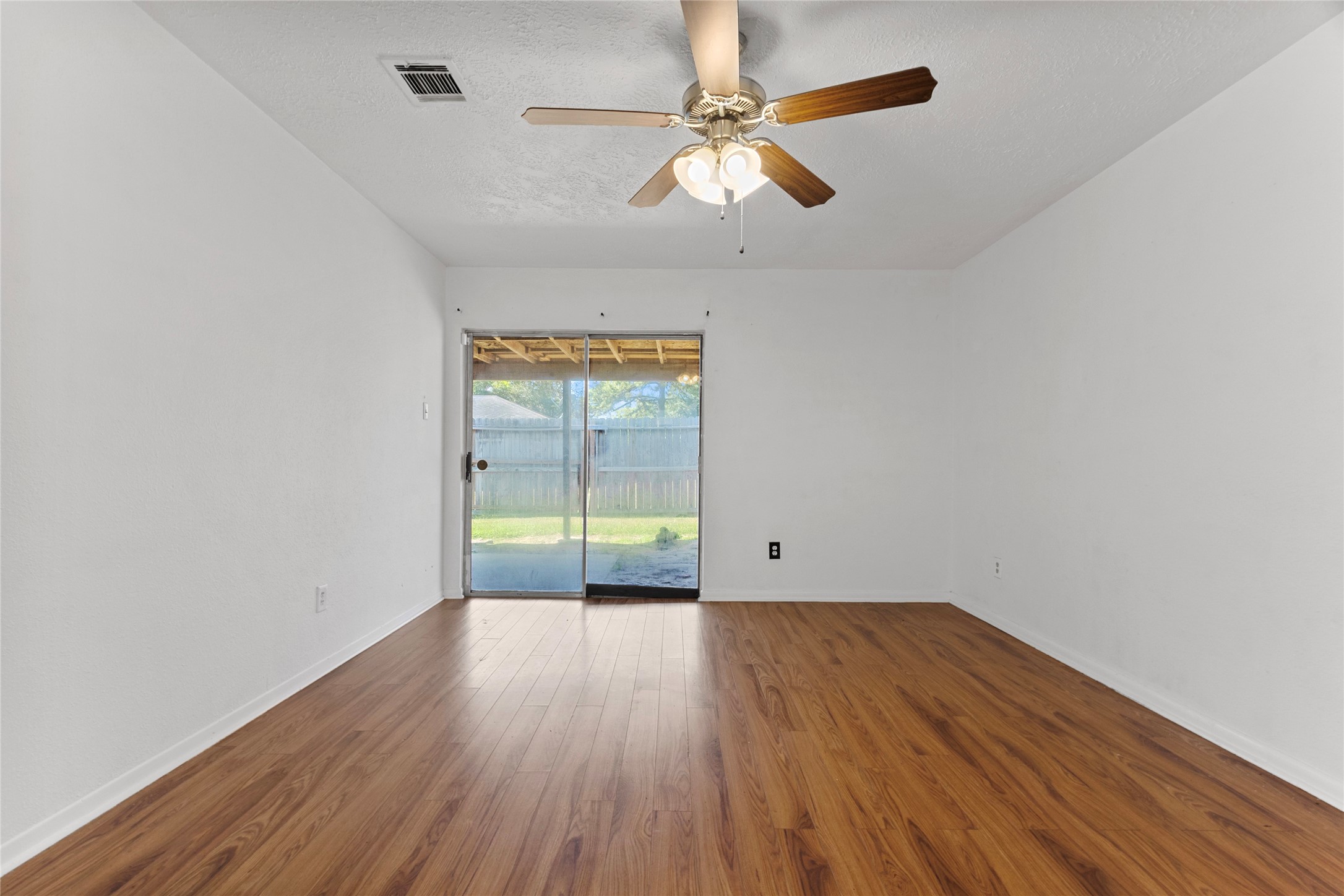 6630 Brownie Campbell Road Houston, TX 77086 - Photo 20 of 28 an empty room with wooden floor and windows