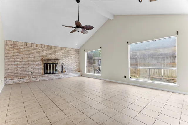 a view of an empty room with a fireplace and a window