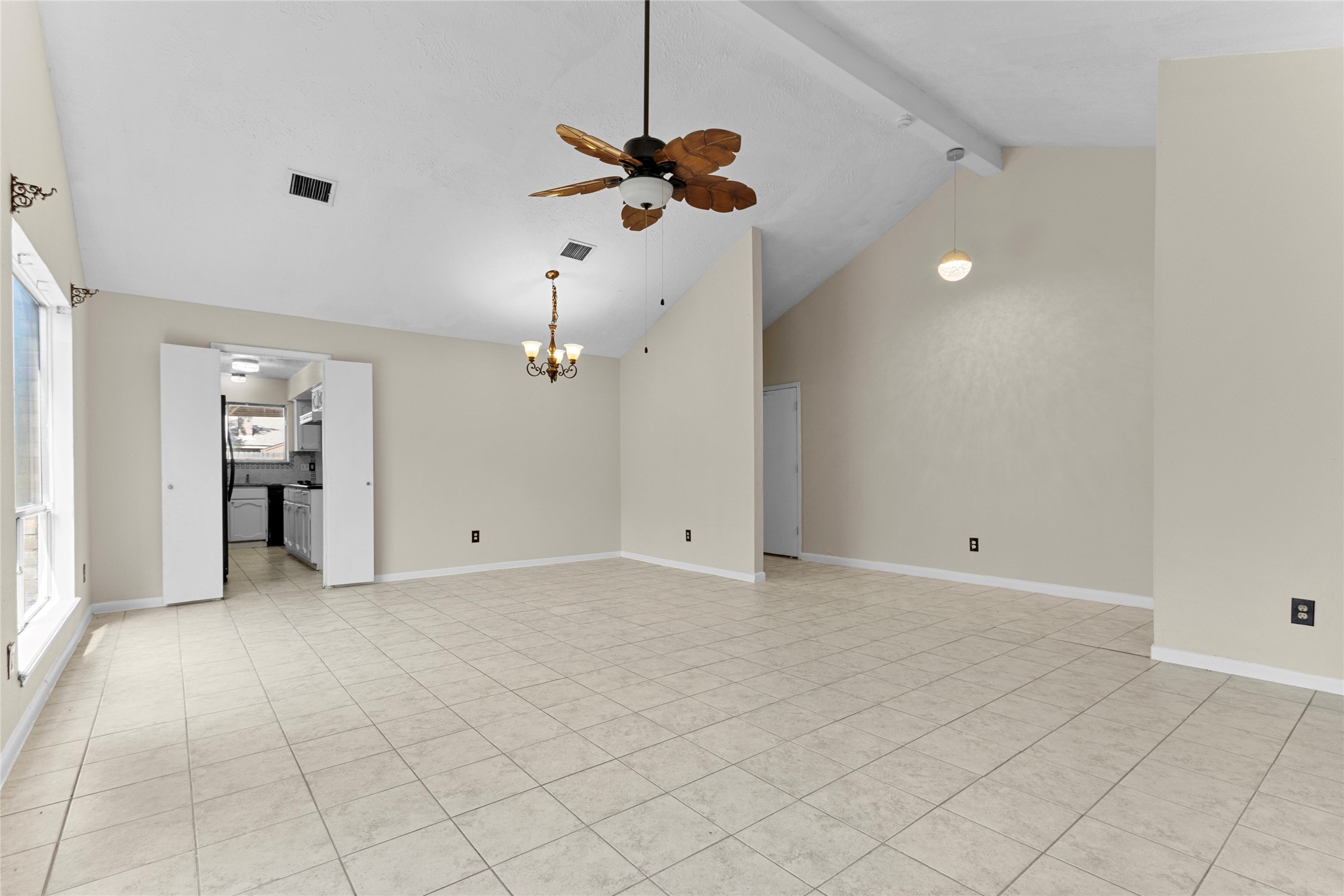 6630 Brownie Campbell Road Houston, TX 77086 - Photo 7 of 28 an empty room with a chandelier fan and windows