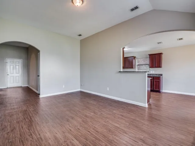 a view of a livingroom with wooden floor and a ceiling fan