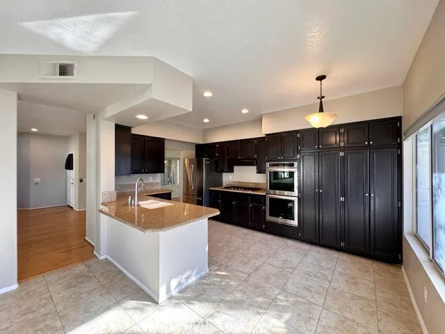 a large kitchen with a stove and cabinets