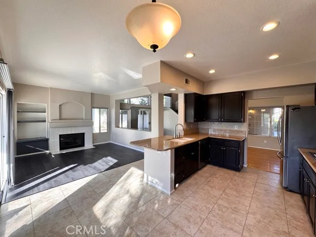 a large kitchen with kitchen island granite countertop a sink and a stove top oven a granite countertops with wooden floor