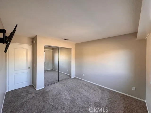 an empty room with closet and wooden floor