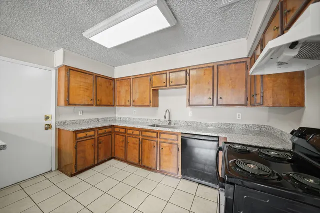 a kitchen with a sink stove top oven and cabinets