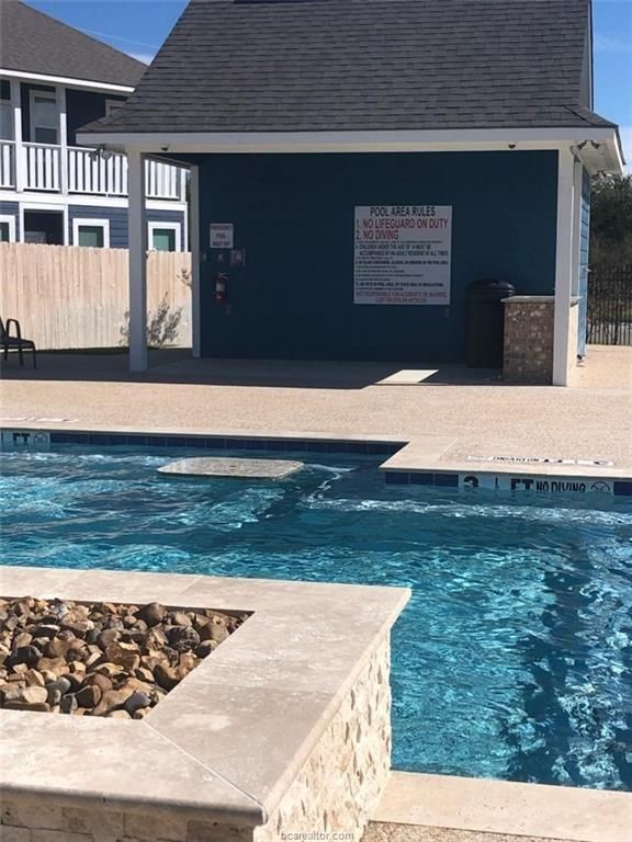 6959 Halter Loop College Station, TX 77845 - Photo 2 of 22 Community pool with fence and a patio area