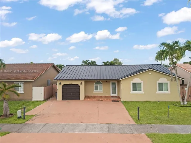 a front view of a house with a garden and plants