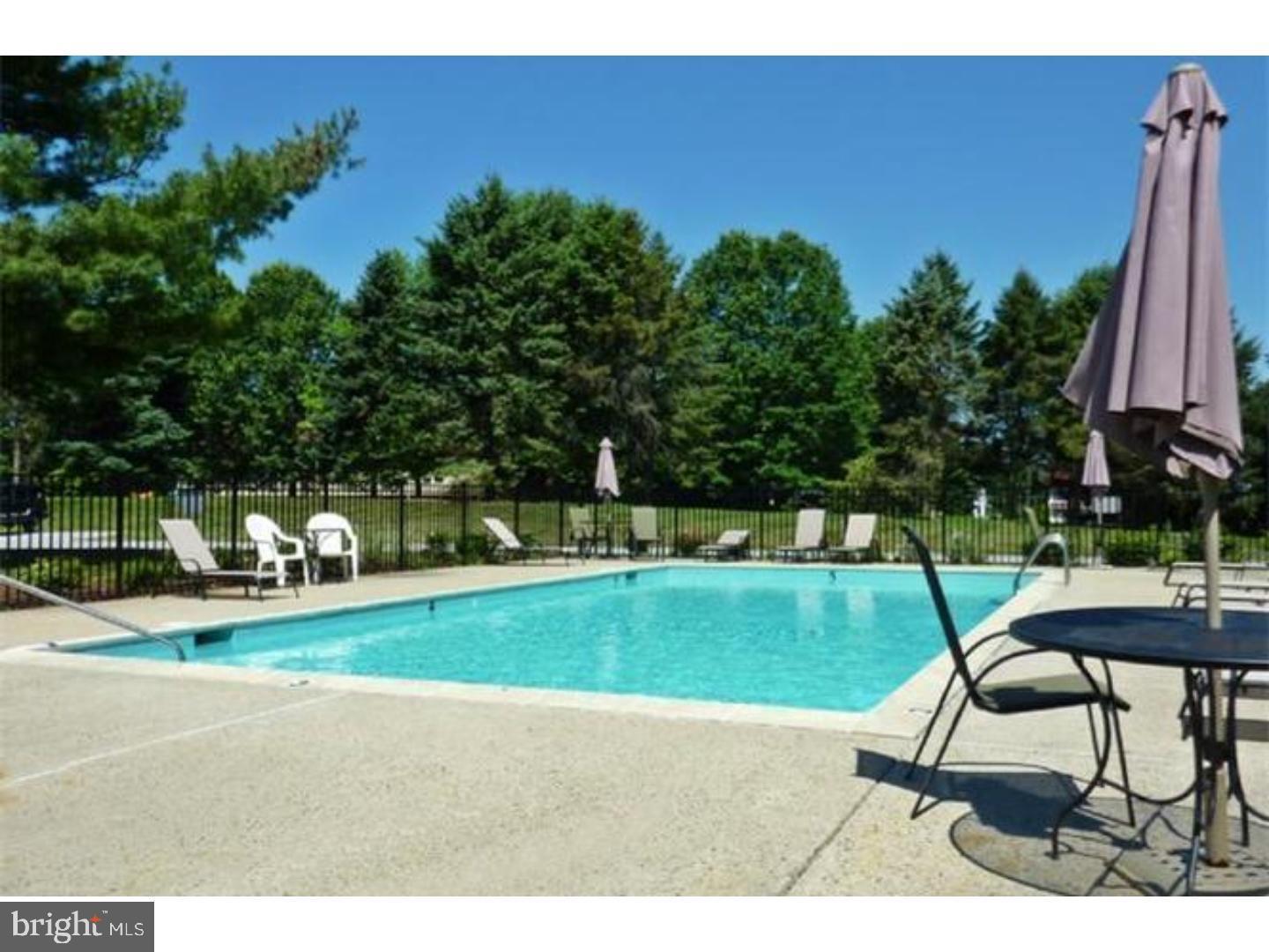 207 Village Walk, Unit 207 Exton, PA 19341 - Photo 17 of 17 Serene poolside retreat surrounded by nature.