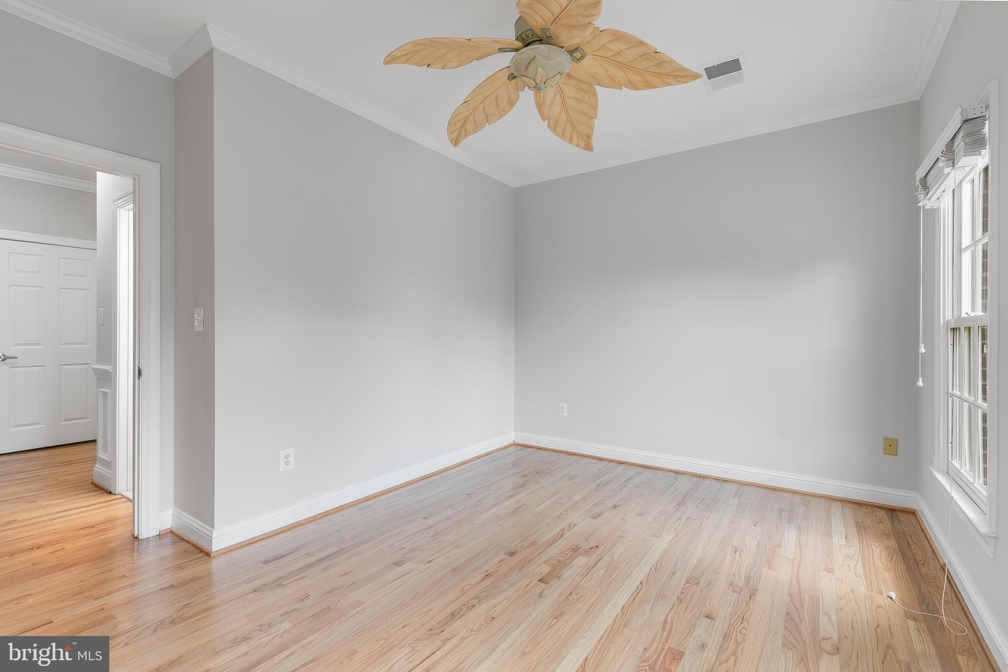 611 Catesby Court Southwest Leesburg, VA 20175 - Photo 51 of 96 an empty room with wooden floor chandelier fan and windows