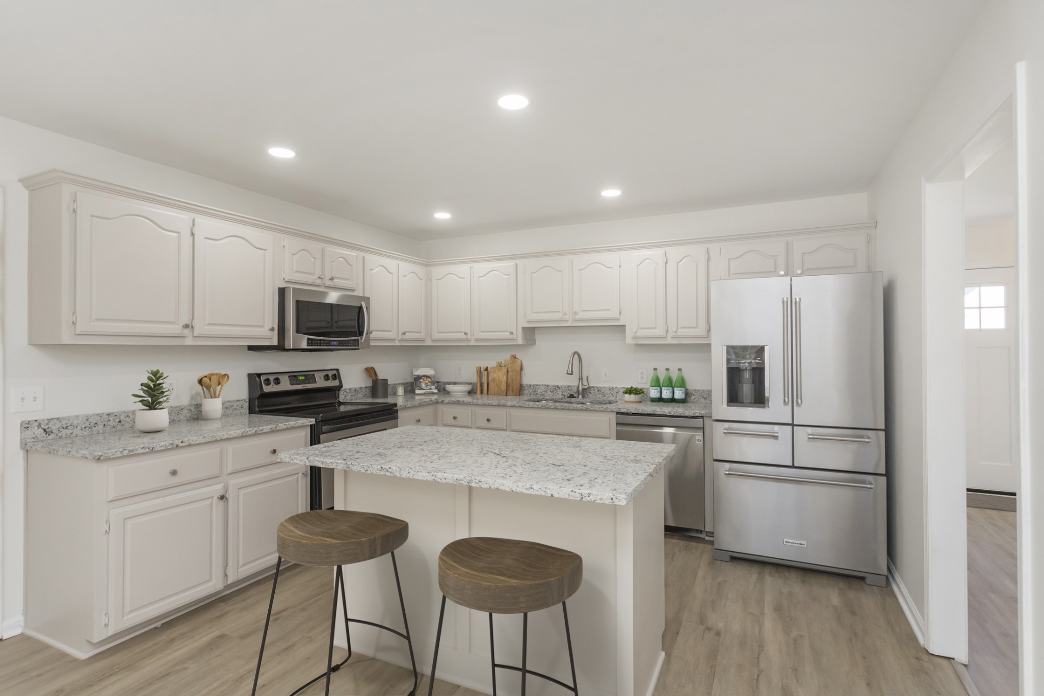 156 Foxrun Springfield, TN 37172 - Photo 3 of 33 a kitchen with kitchen island granite countertop a stove a sink a refrigerator and white cabinets with wooden floor