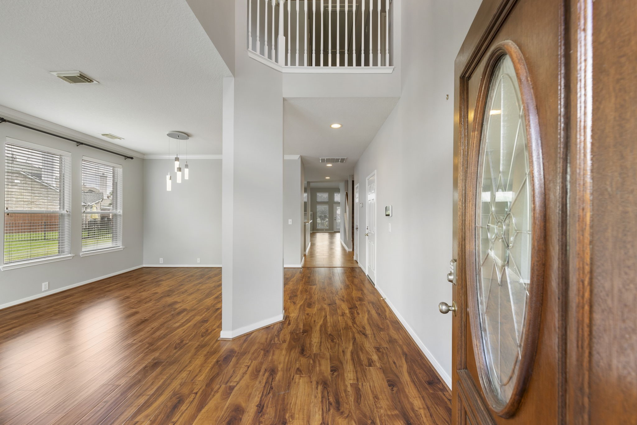 2907 Stemwood Drive Spring, TX 77388 - Photo 4 of 33 Step inside to soaring ceilings, rich wood-look flooring, and an abundance of natural light throughout the welcoming entry. The open-concept layout creates a bright and airy feel with elegant sightlines extending through the home.