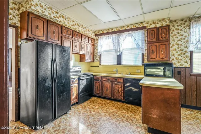 a kitchen with stainless steel appliances granite countertop a refrigerator a stove and a sink