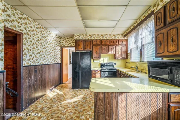 a kitchen with stainless steel appliances kitchen island granite countertop a refrigerator and a stove top oven