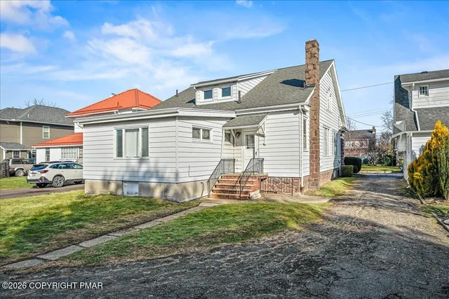 a view of a house with a yard and sitting area