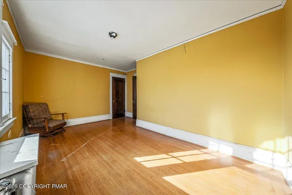 a view of a room with wooden floor and small window