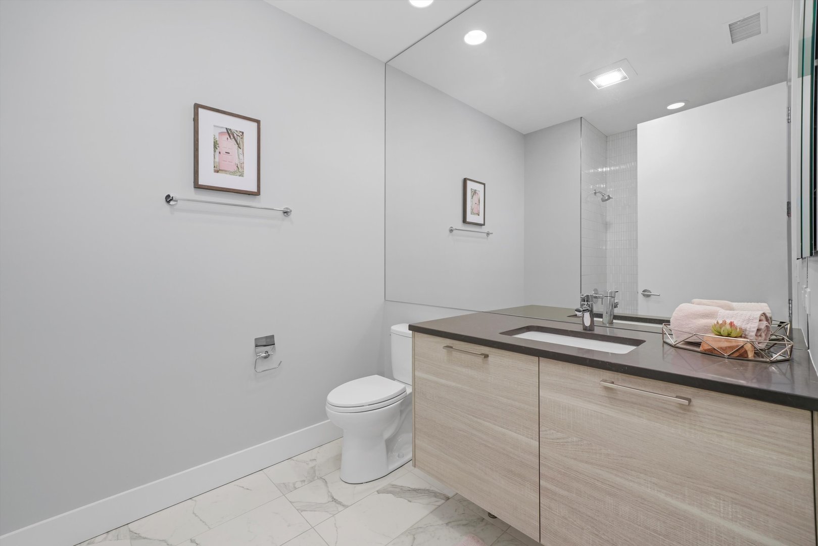 1128 West Adams Street, Unit 4E Chicago, IL 60607 - Photo 12 of 31 a bathroom with a granite countertop sink a toilet and mirror