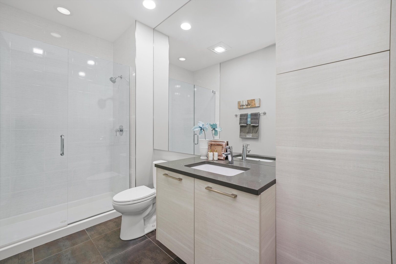 1128 West Adams Street, Unit 4E Chicago, IL 60607 - Photo 15 of 31 a bathroom with a granite countertop sink a toilet a mirror and shower