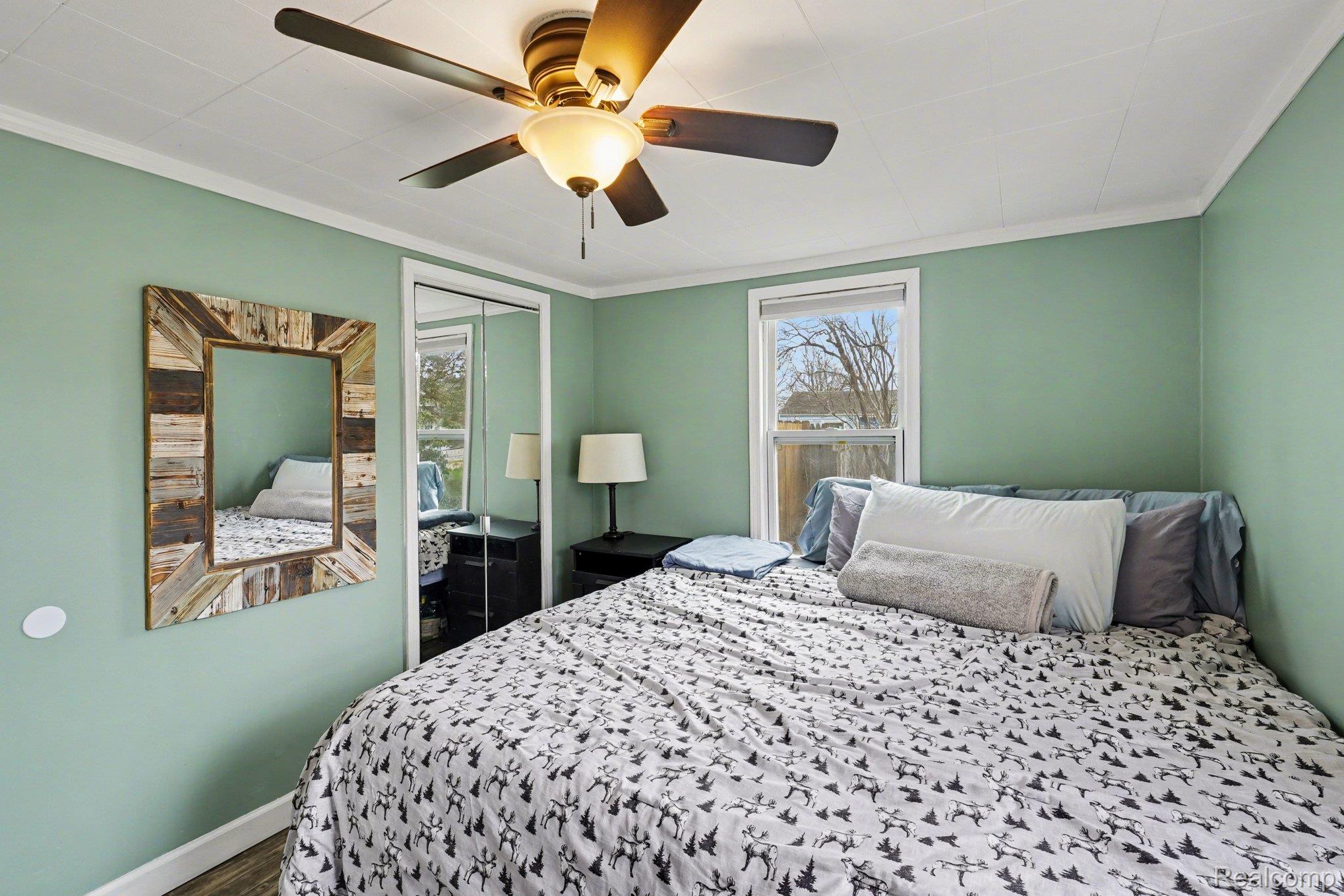 16485 Jennings Road Fenton, MI 48430 - Photo 21 of 27 Bedroom featuring a closet, ceiling fan, crown molding, and wood finished floors
