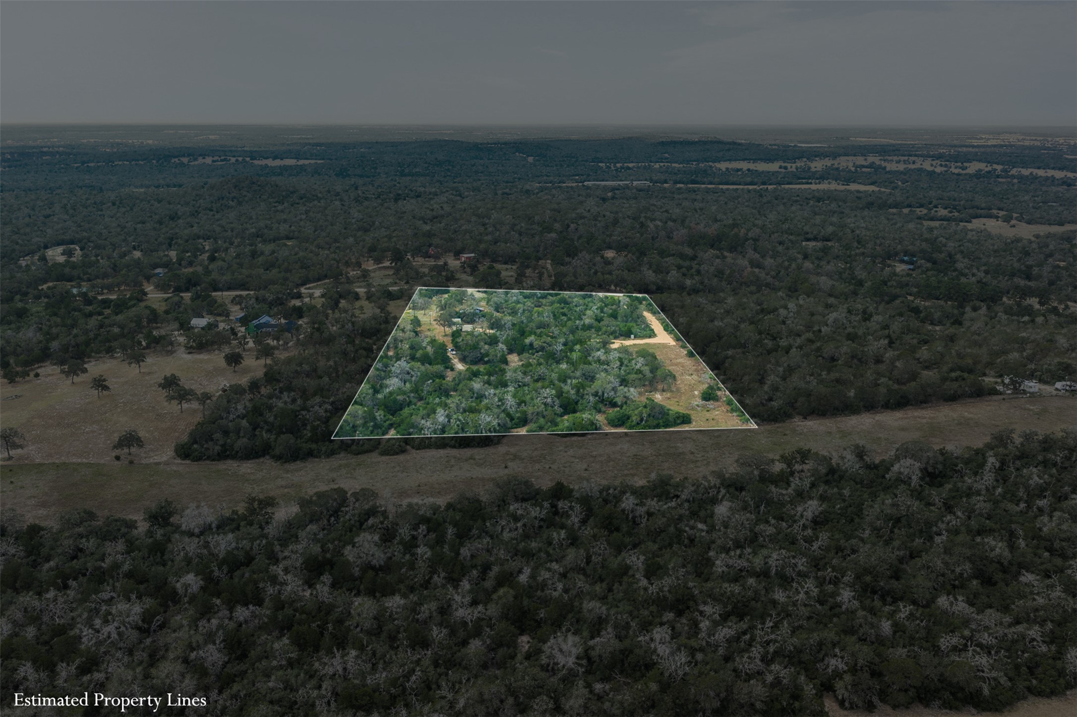 3301 Chuckwagon Road Harwood, TX 78632 - Photo 22 of 36 An aerial perspective showcases a secluded, heavily wooded parcel surrounded by rolling forest terrain.