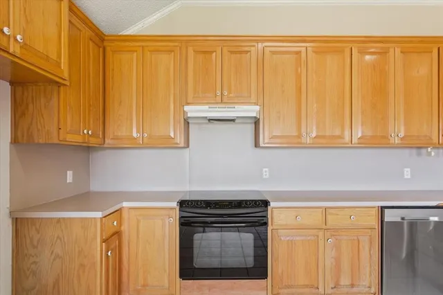 a kitchen with stainless steel appliances granite countertop white cabinets and a refrigerator