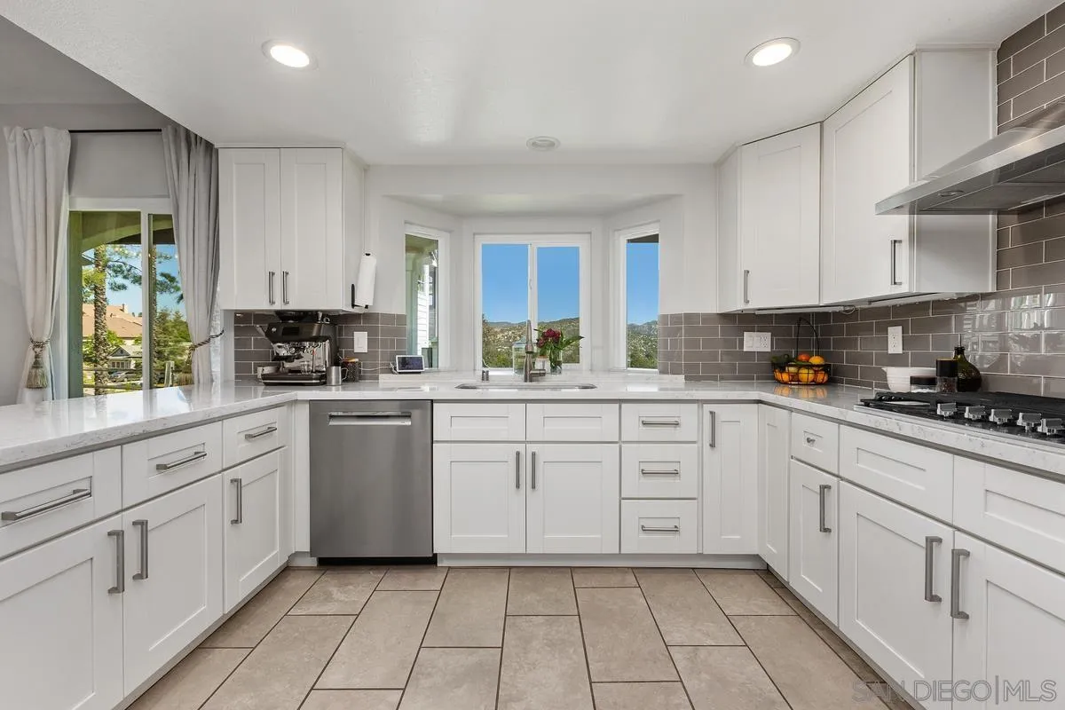 23969 Nectar Way Ramona, CA 92065 - Photo 20 of 54 a kitchen with white cabinets appliances a sink and a window