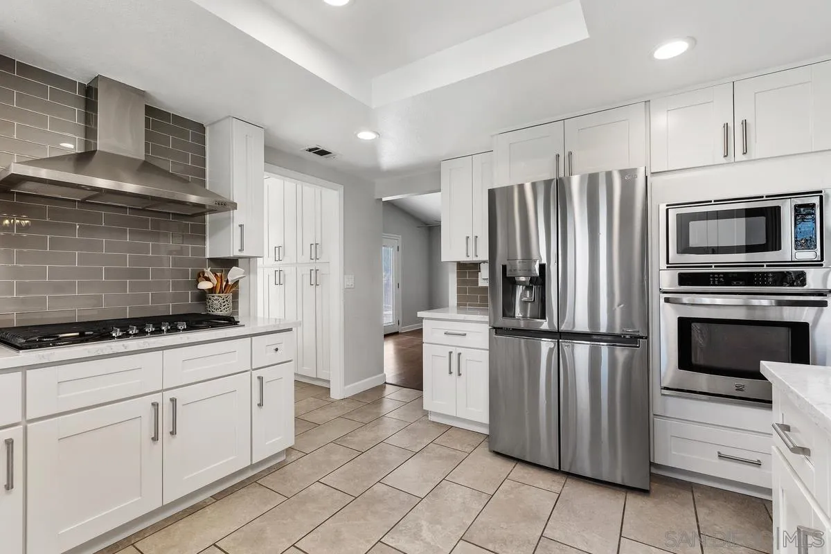 23969 Nectar Way Ramona, CA 92065 - Photo 21 of 54 a kitchen with white cabinets and stainless steel appliances