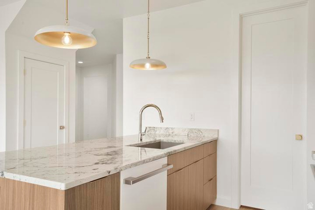 990 Manen Street Washington, UT 84780 - Photo 8 of 43 Kitchen island featuring a stone countertop, an undermount sink with a gooseneck faucet, and integrated dishwasher