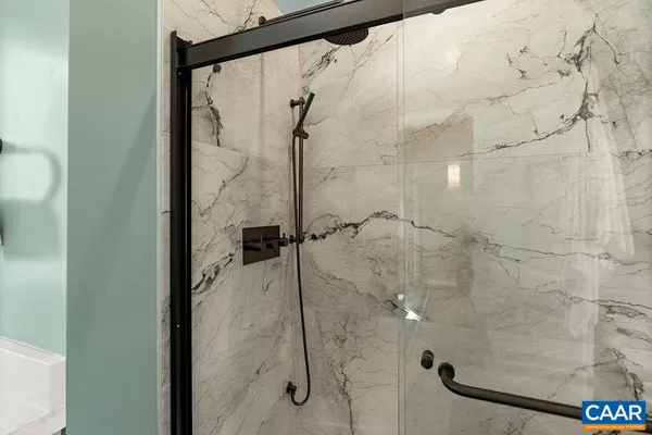 a hallway with a sink a mirror and a wooden floor