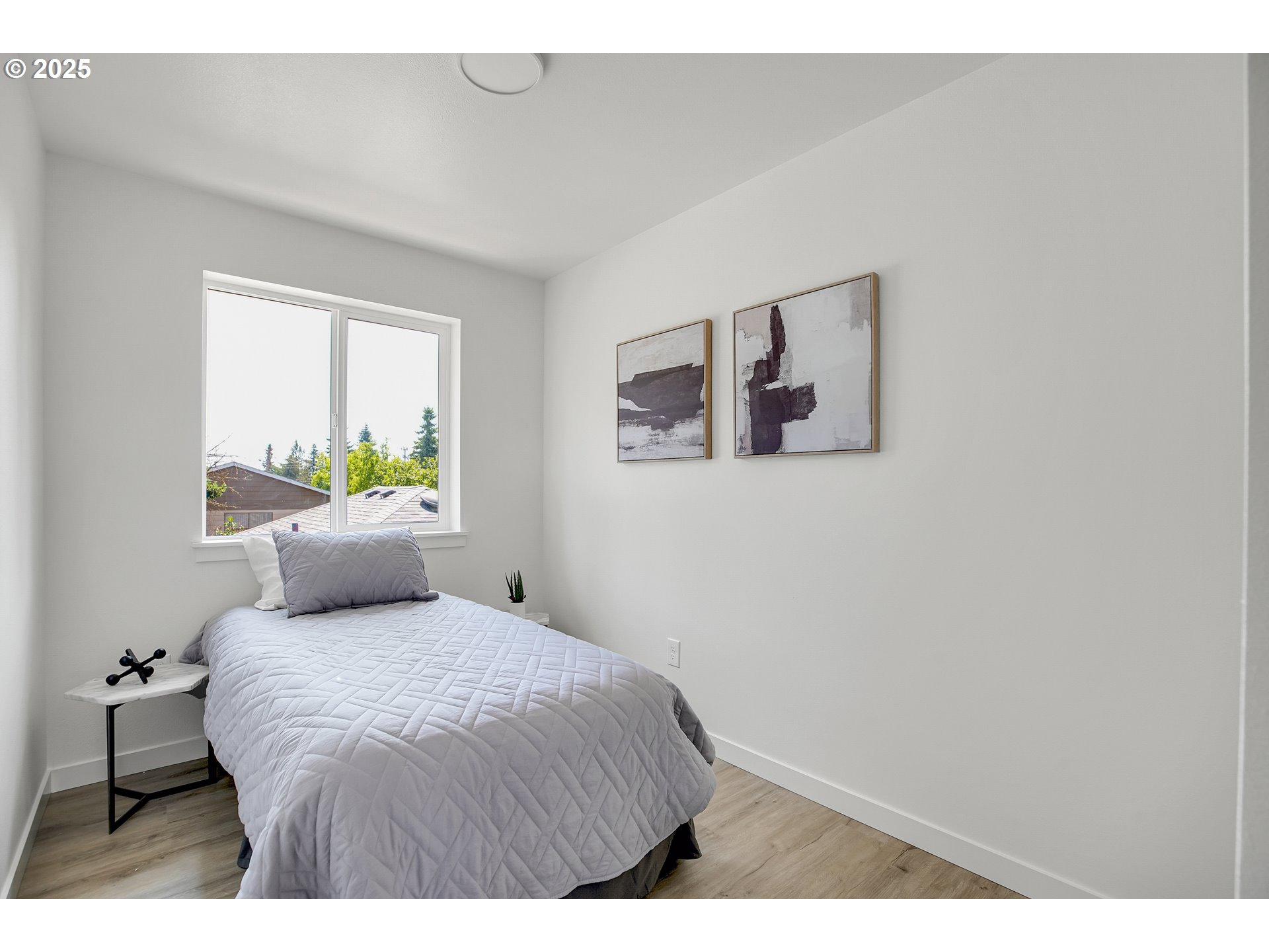 14852 Northeast Couch Street, Unit 9 Portland, OR 97230 - Photo 17 of 42 a bedroom with a bed and painting on the wall