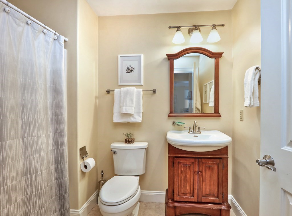 426 Main Street, Unit 402 Melrose, MA 02176 - Photo 13 of 24 a bathroom with a toilet sink and mirror