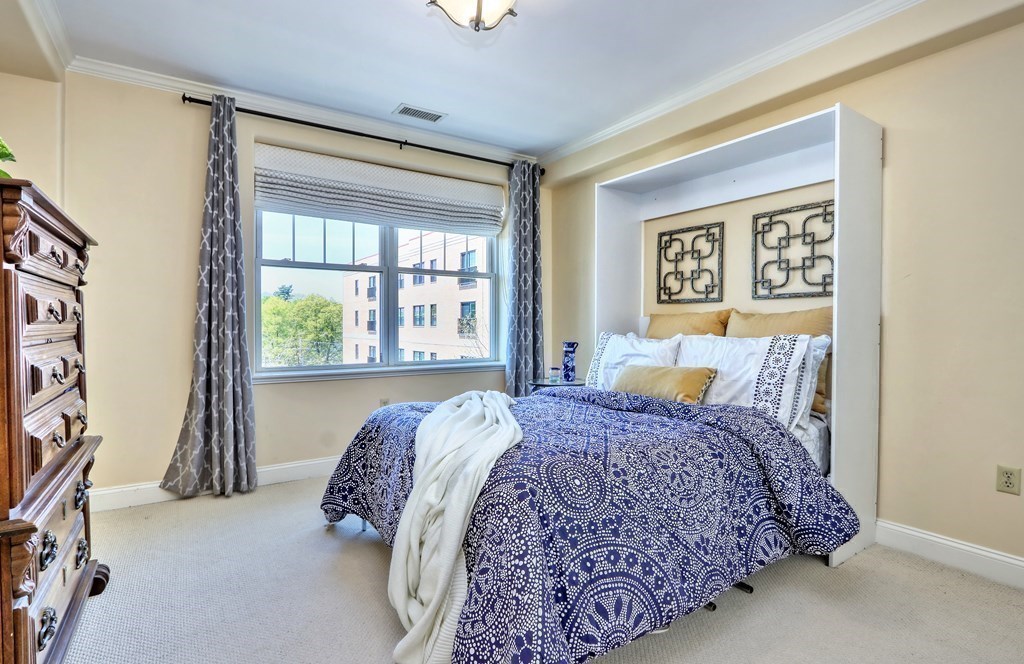 426 Main Street, Unit 402 Melrose, MA 02176 - Photo 18 of 24 a bed sitting in a bedroom next to a window