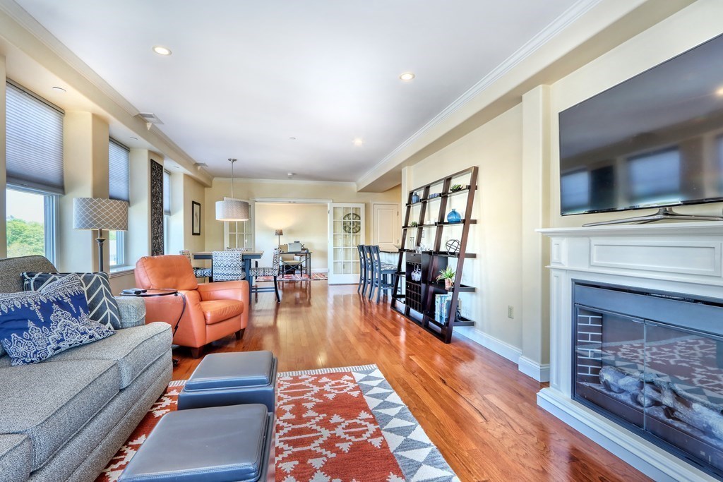 426 Main Street, Unit 402 Melrose, MA 02176 - Photo 9 of 24 a living room with furniture a fireplace and a flat screen tv