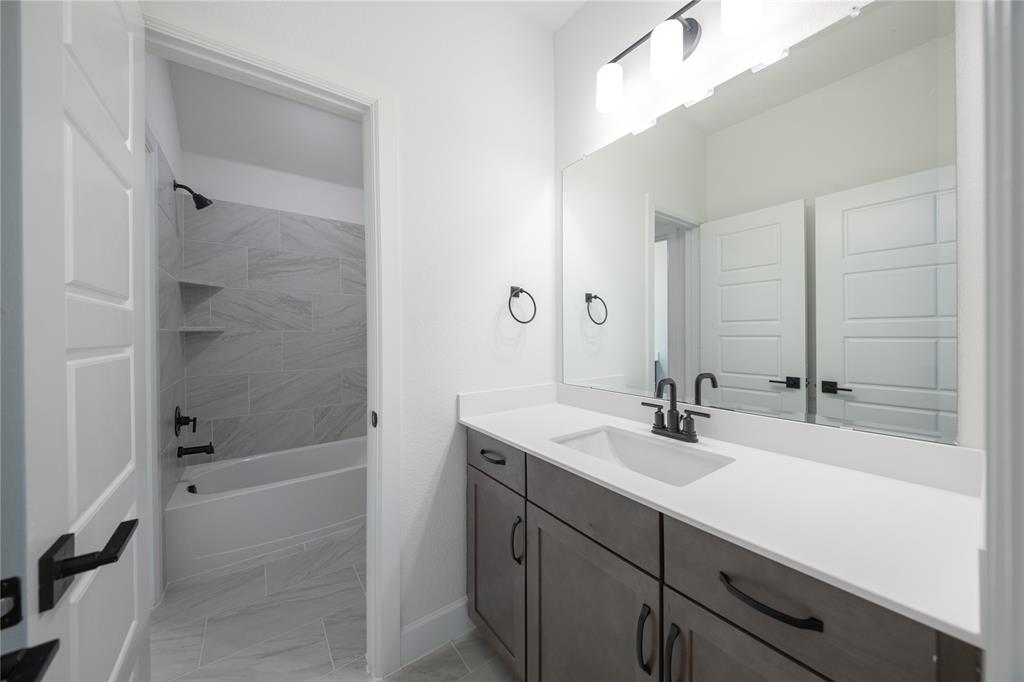 2719 Triumph Court Heath, TX 75126 - Photo 4 of 39 a bathroom with a bathtub shower sink vanity and mirror