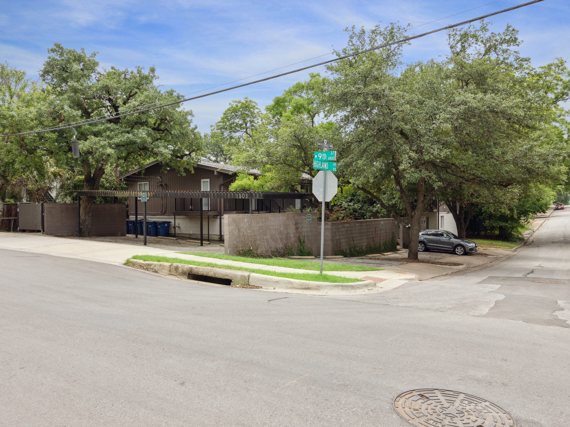 1503 West 9th Street, Unit 204 Austin, TX 78703 - Photo 19 of 21 Multi-story brown siding exterior with a carport and multiple mature trees