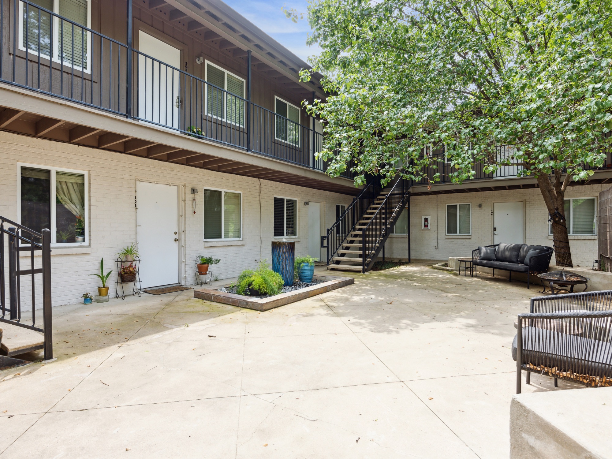 1503 West 9th Street, Unit 204 Austin, TX 78703 - Photo 2 of 21 Central courtyard with concrete paving, mature tree, and planter box