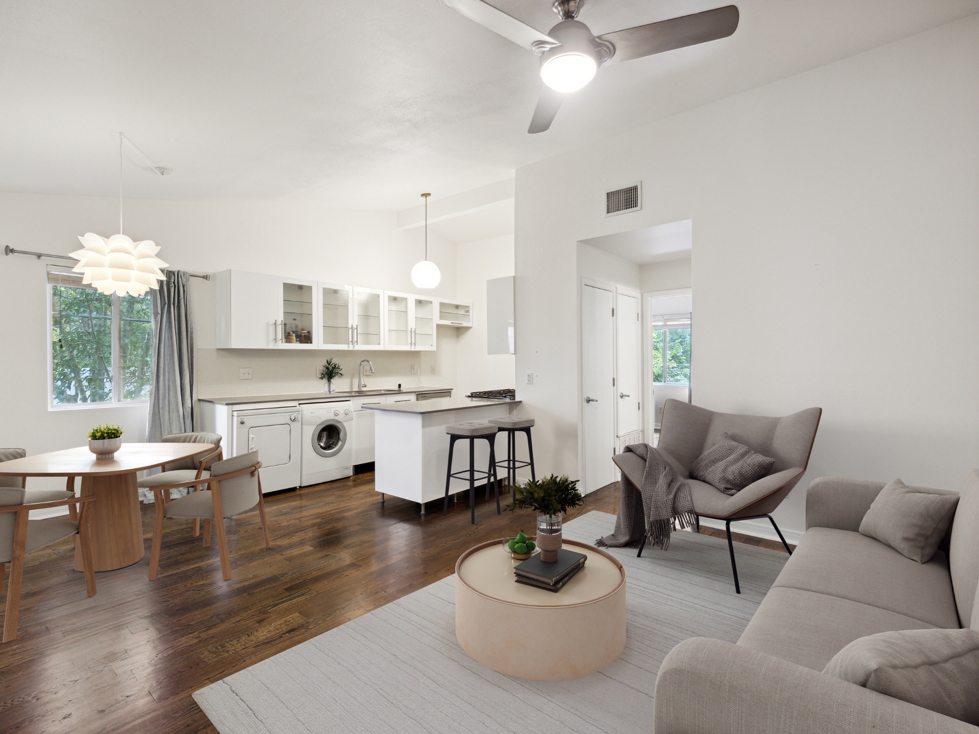 1503 West 9th Street, Unit 204 Austin, TX 78703 - Photo 8 of 21 Open-concept living space featuring wood-finish flooring, white walls, and a modern kitchen with white cabinetry
