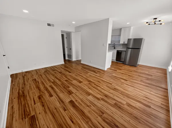 a view of empty room with wooden floor