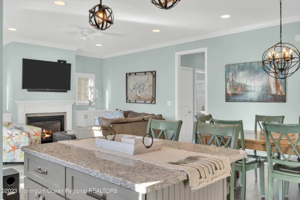 a view of a dining room and livingroom with furniture wooden floor a chandelier