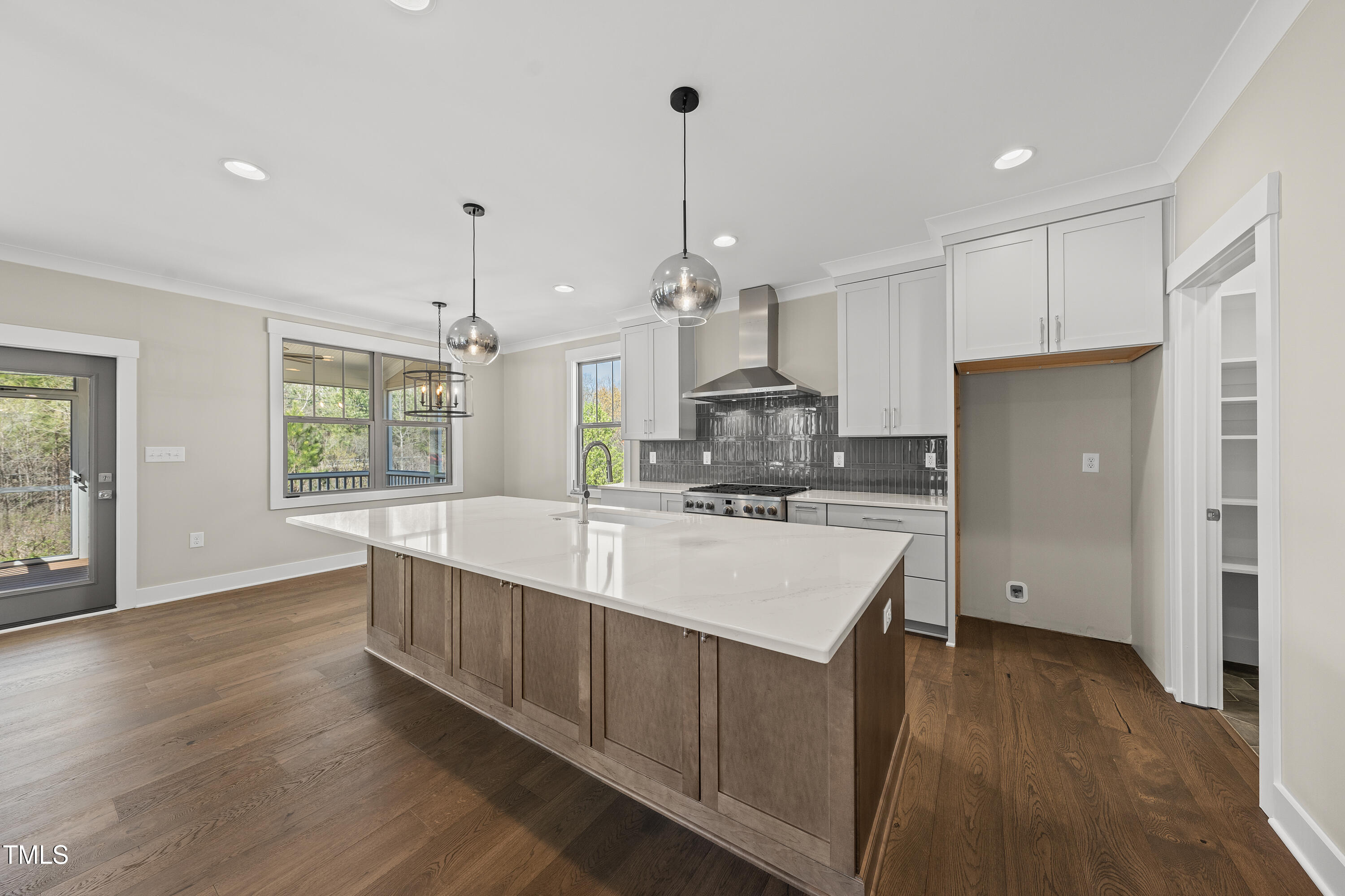 10119 2nd Star Court Raleigh, NC 27613 - Photo 11 of 39 a large kitchen with kitchen island white cabinets stainless steel appliances a sink and wooden floor