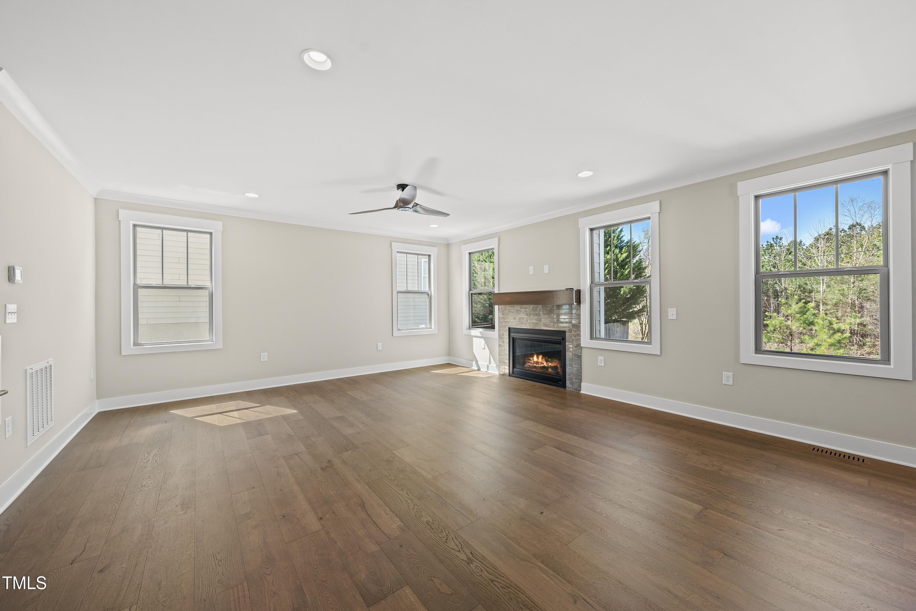 10119 2nd Star Court Raleigh, NC 27613 - Photo 16 of 39 an empty room with windows fireplace and wooden floor