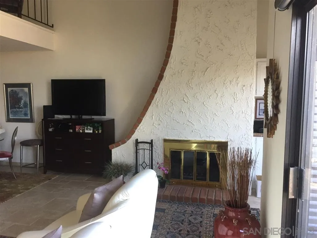1939 Alga Road, Unit A Carlsbad, CA 92009 - Photo 5 of 25 a living room with furniture and a fireplace