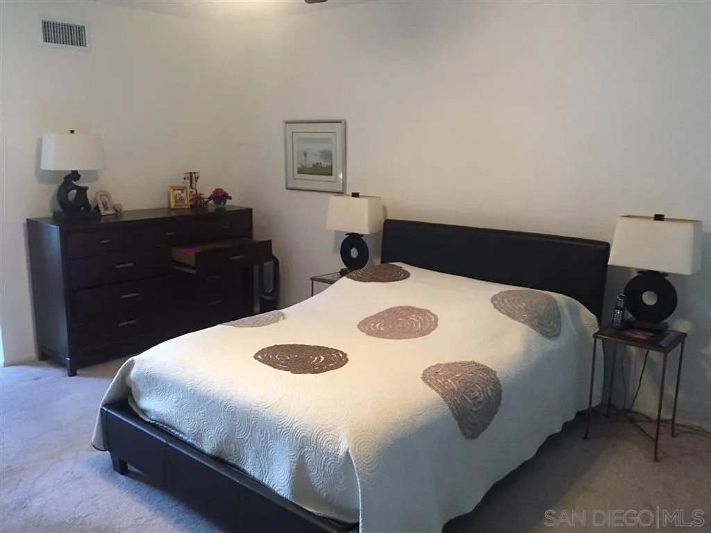 1939 Alga Road, Unit A Carlsbad, CA 92009 - Photo 9 of 25 a bedroom with a bed and a dresser