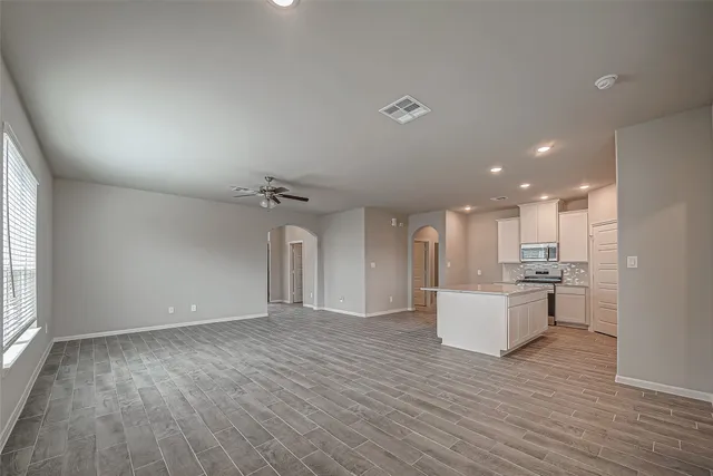 a kitchen with a sink dishwasher and white cabinets with wooden floor