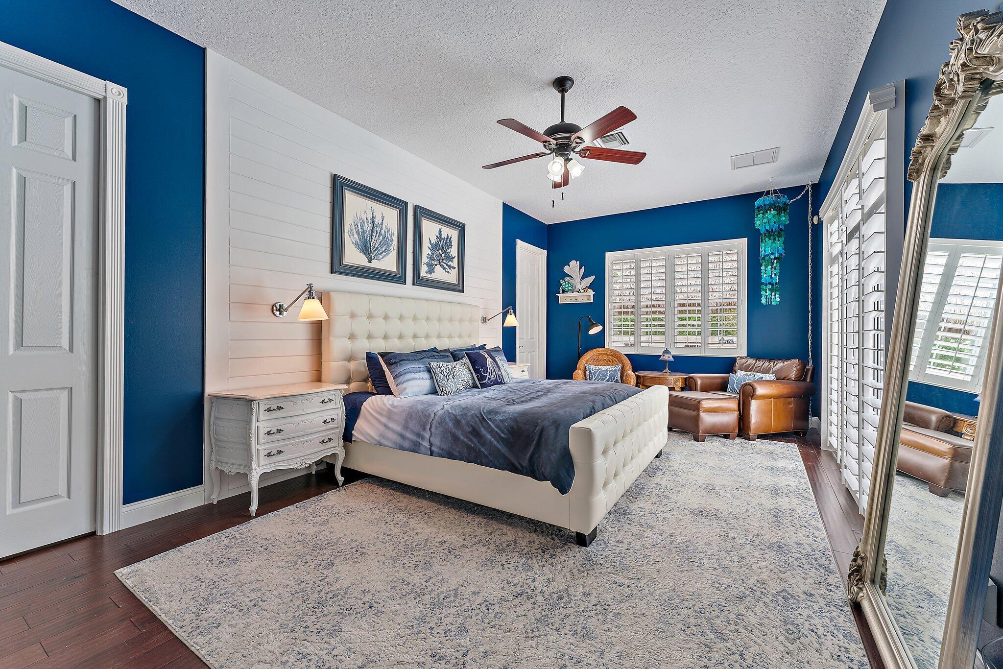 334 Caravelle Drive Jupiter, FL 33458 - Photo 23 of 55 a bedroom with a bed and a chandelier