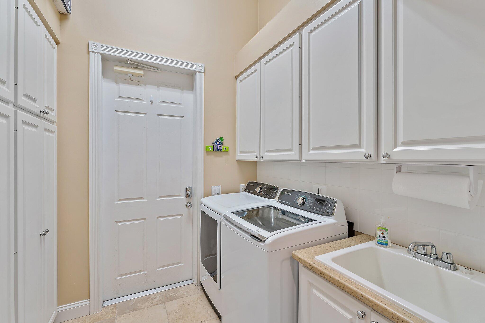 334 Caravelle Drive Jupiter, FL 33458 - Photo 30 of 55 a utility room with sink dryer and washer