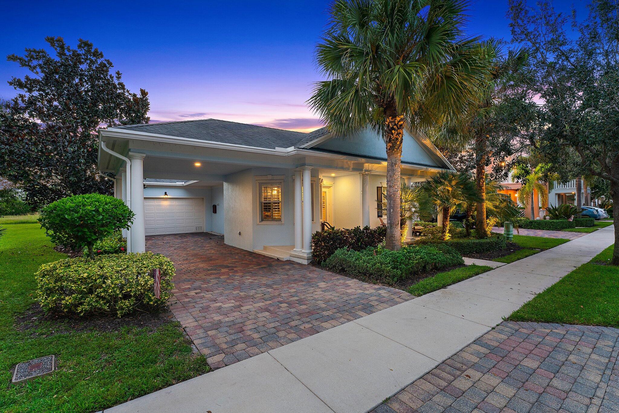334 Caravelle Drive Jupiter, FL 33458 - Photo 48 of 55 a front view of a house with a yard and garage