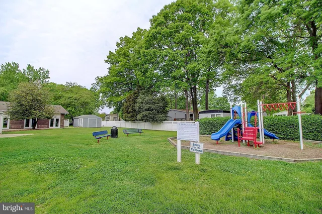 a front view of a house with a garden and trees