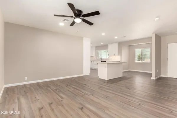 a view of an empty room with a window and wooden floor