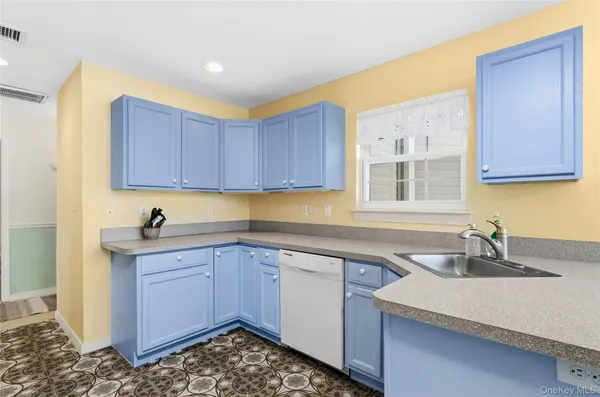 a kitchen with a sink cabinets and wooden floor