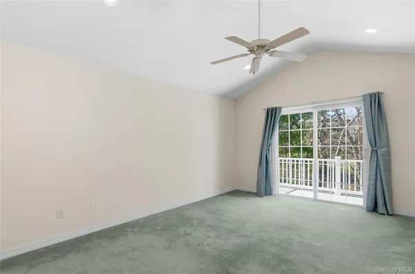 an empty room with a ceiling fan and windows